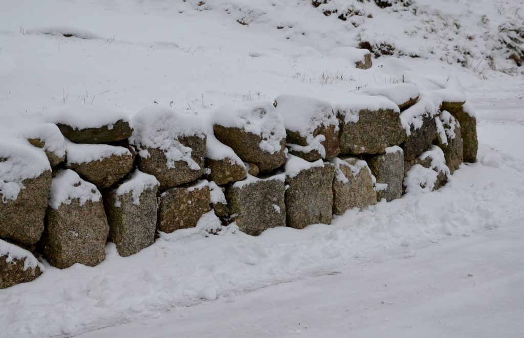 Snowy granite boulder retaining wall - common cause of snow plow damage