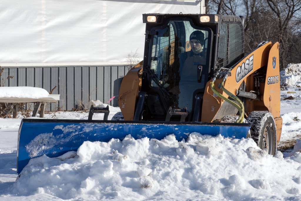 SnowFire Skid Steer Snow Plow windrowing on a farm