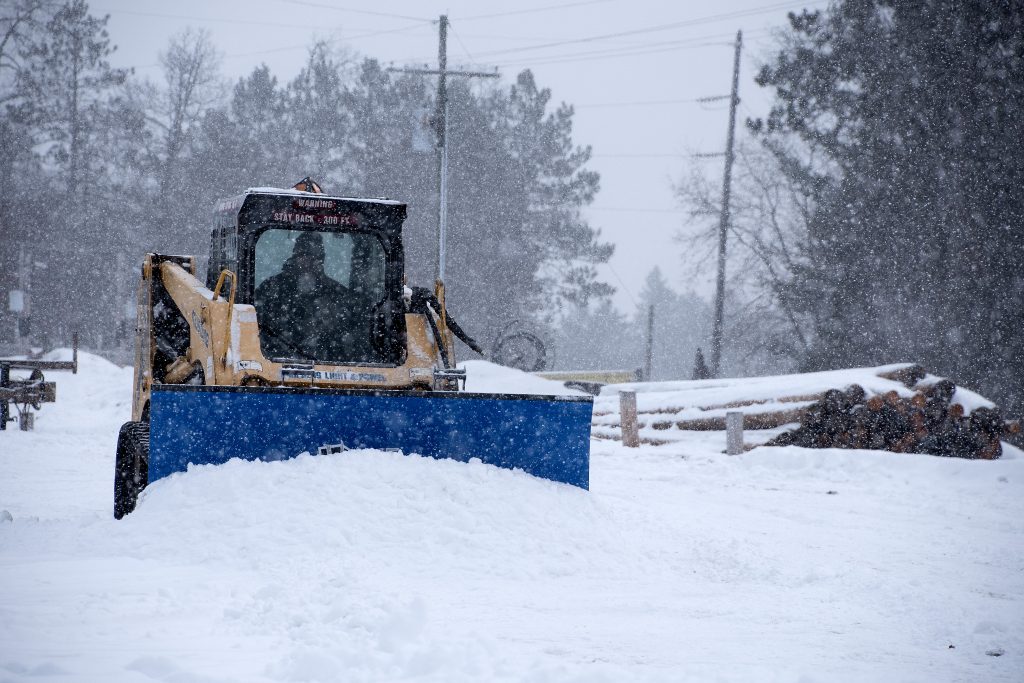 Electric Company Clearing Snow With a Compact Track Loader