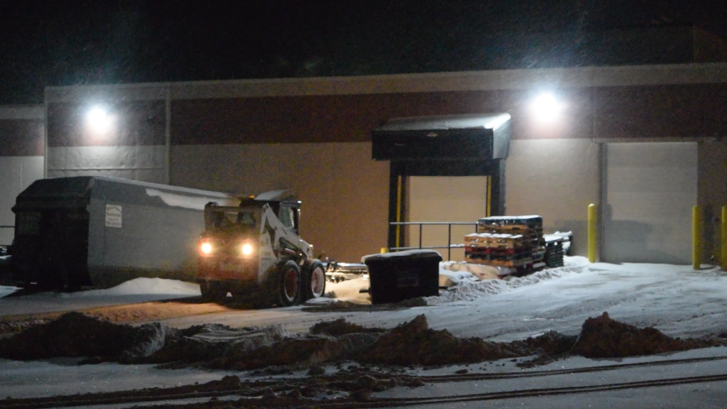 KAGE Klawz and SnowFire Plow on Skid Steer back dragging a loading dock